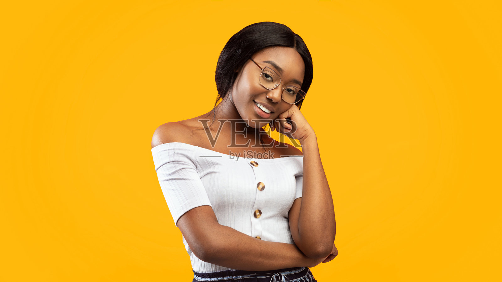 美丽的女士微笑着在工作室中摆姿势，手托下巴，全景图照片摄影图片