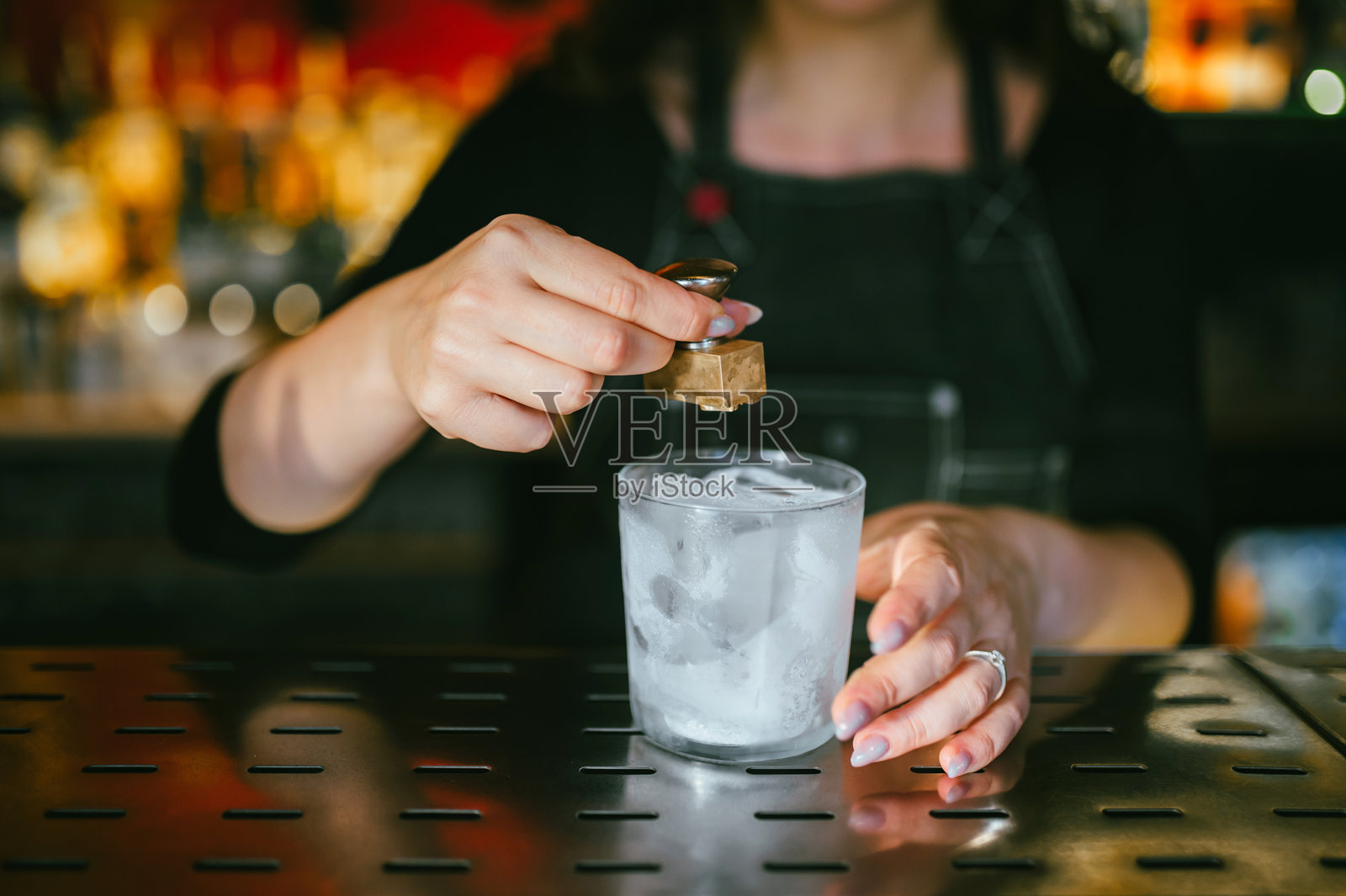 调酒师正在调制鸡尾酒，调酒师正在为鸡尾酒敲打冰块照片摄影图片