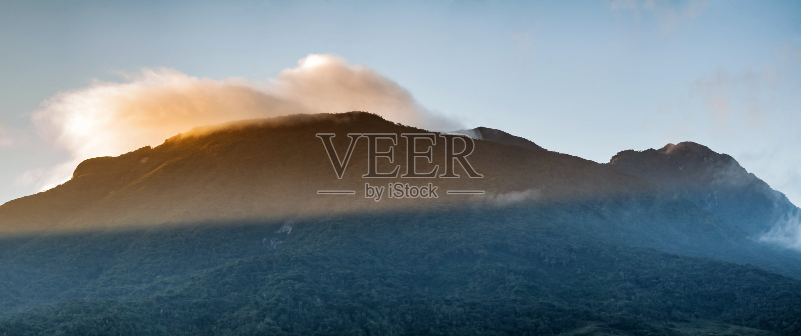 黎明时分的山脉剪影，阳光透过云层洒下，象征着新的一天、新的目标和机会，展现出美丽的安第斯全景，深邃而茂密的森林。照片摄影图片