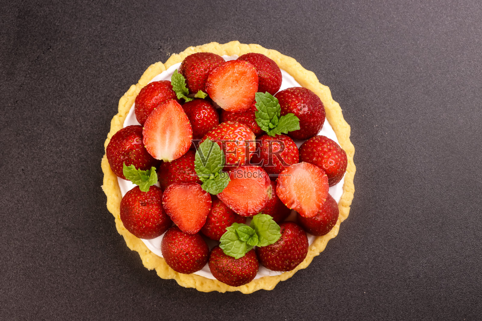 草莓挞配奶油，装饰薄荷叶。照片摄影图片