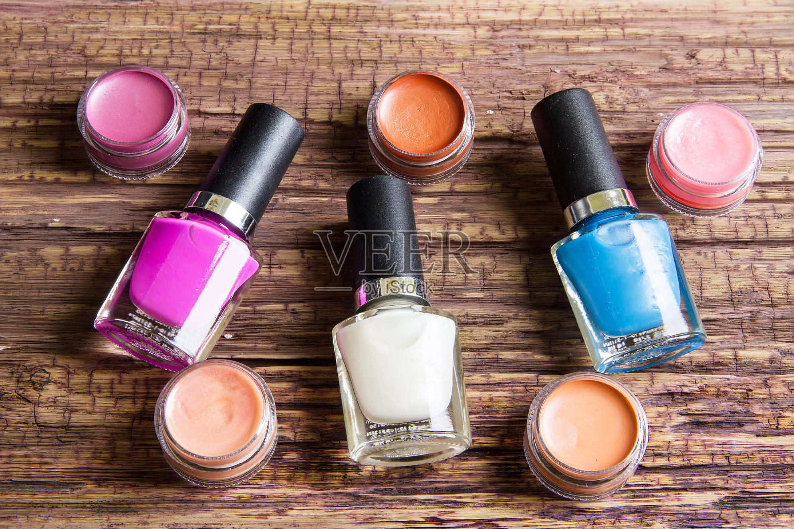 高角度视图的指甲油瓶和木桌上的润唇膏照片摄影图片