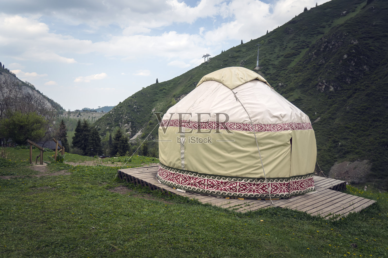 毡房。哈萨克斯坦和亚洲国家人民的传统古老住宅。民族住房。毡房位于绿色草地和高山的背景下。照片摄影图片