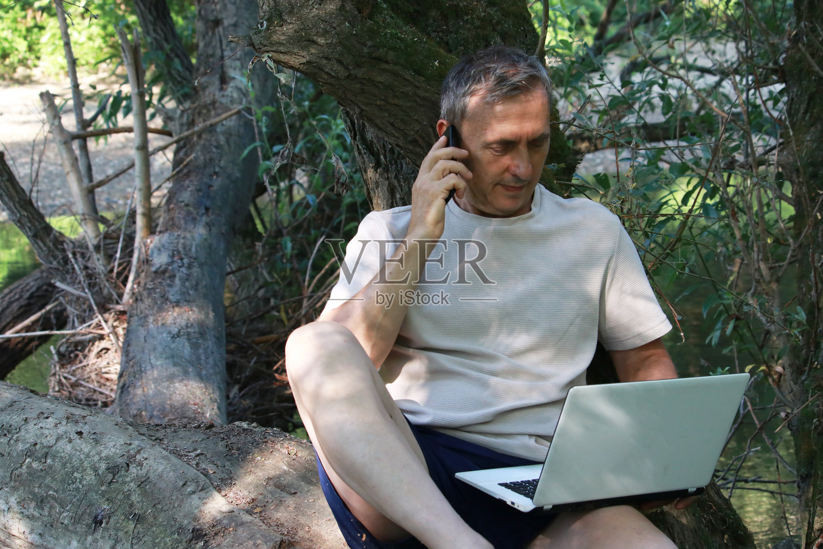 成熟男性在自然中使用科技进行商务活动照片摄影图片