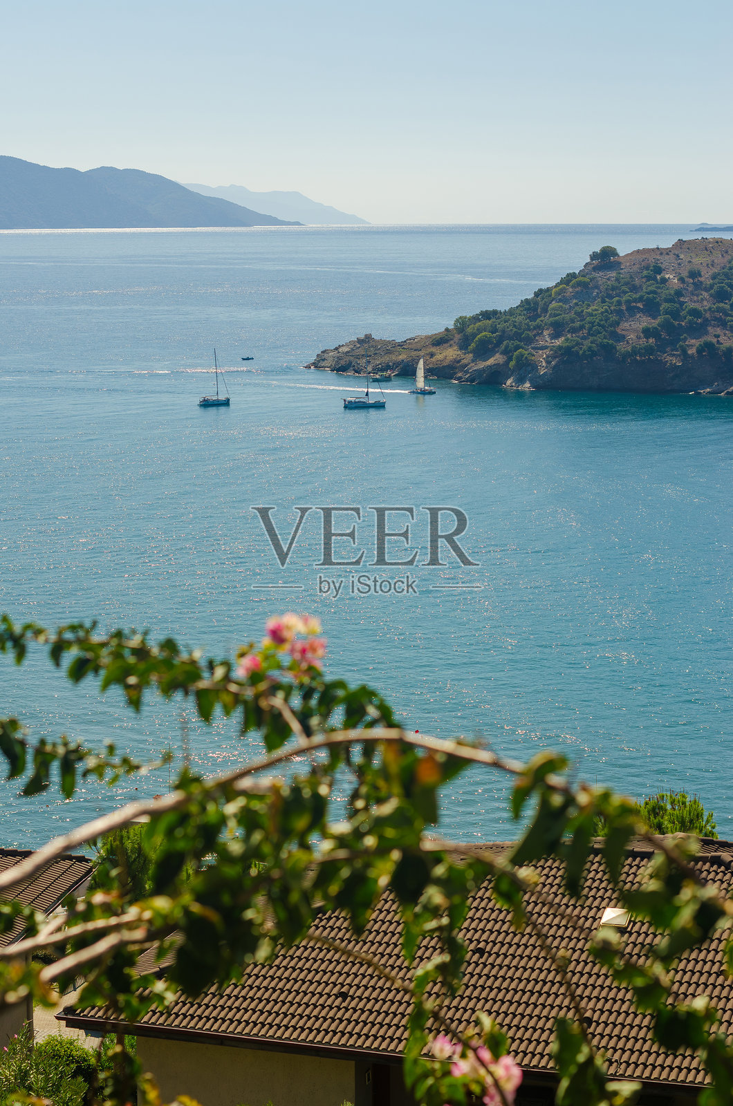 从酒店阳台俯瞰爱琴海，阳光明媚，海面上停着几艘游艇。照片摄影图片