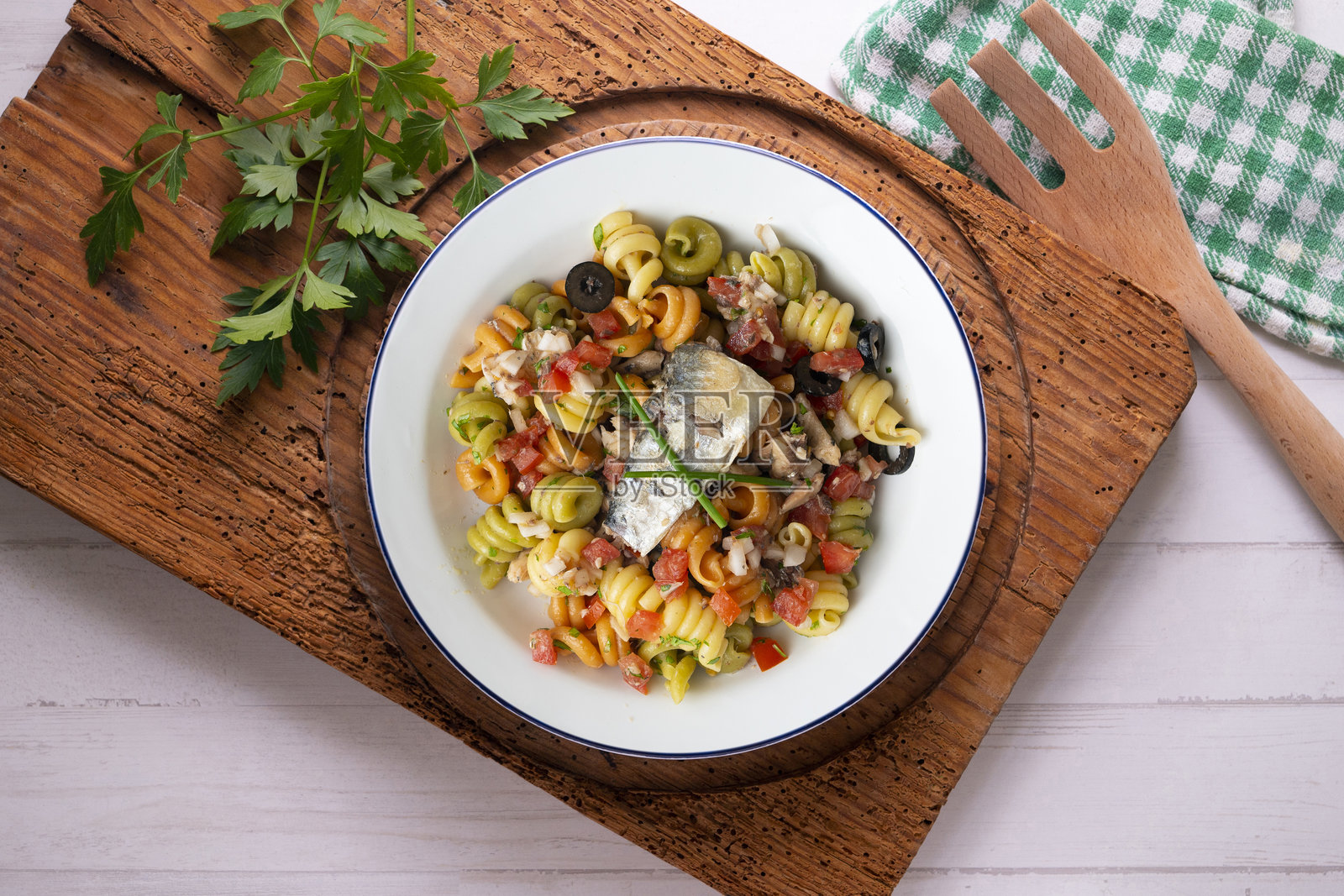 意大利面配沙丁鱼和黑橄榄。顶部视角的桌子上摆放着圣诞装饰。照片摄影图片