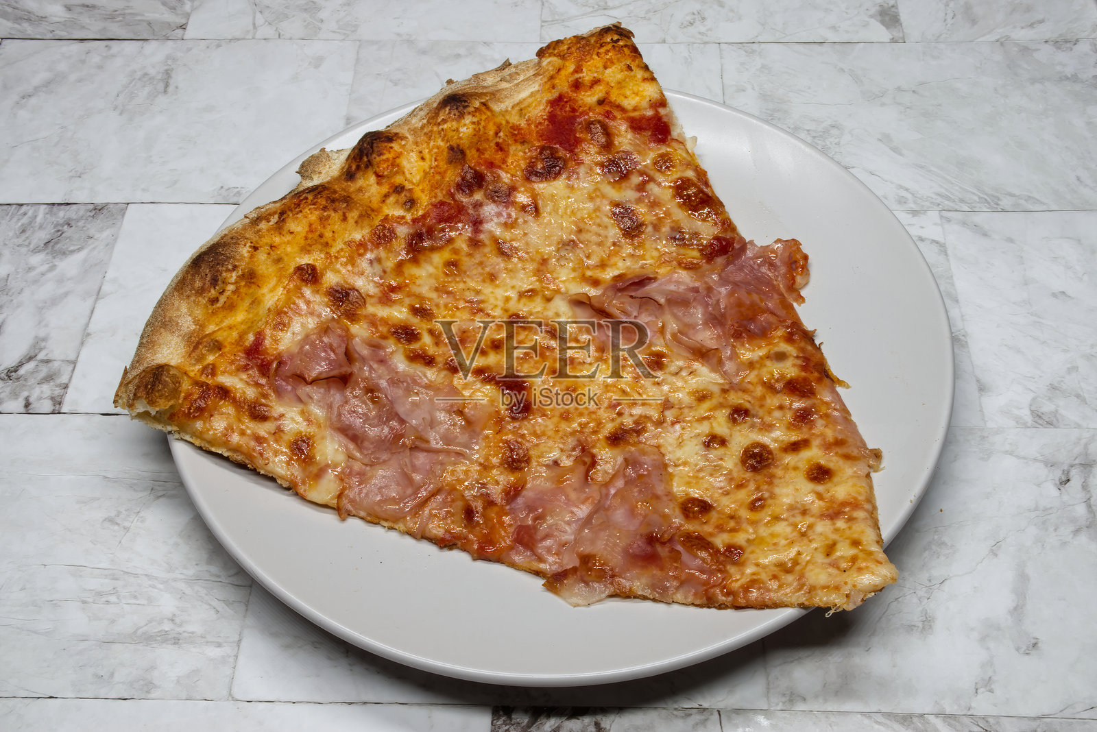 白盘中的意大利火腿和马苏里拉奶酪披萨切片。照片摄影图片