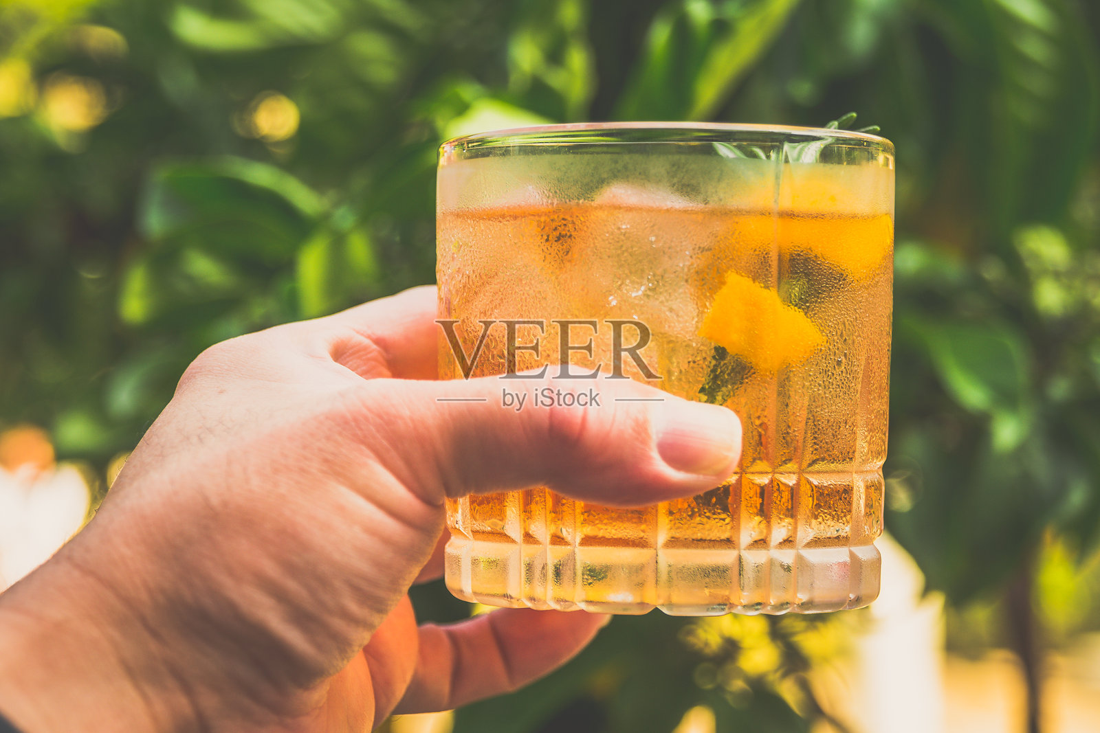 一杯由威士忌、自制迷迭香糖浆和苦味酒调制而成的鸡尾酒，盛在玻璃杯中。照片摄影图片