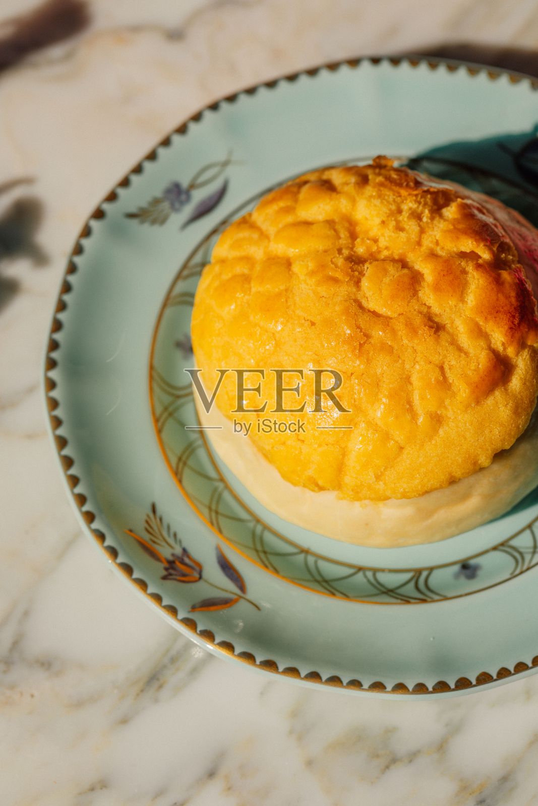 蓝色盘子上的金色奶油烤包子照片摄影图片