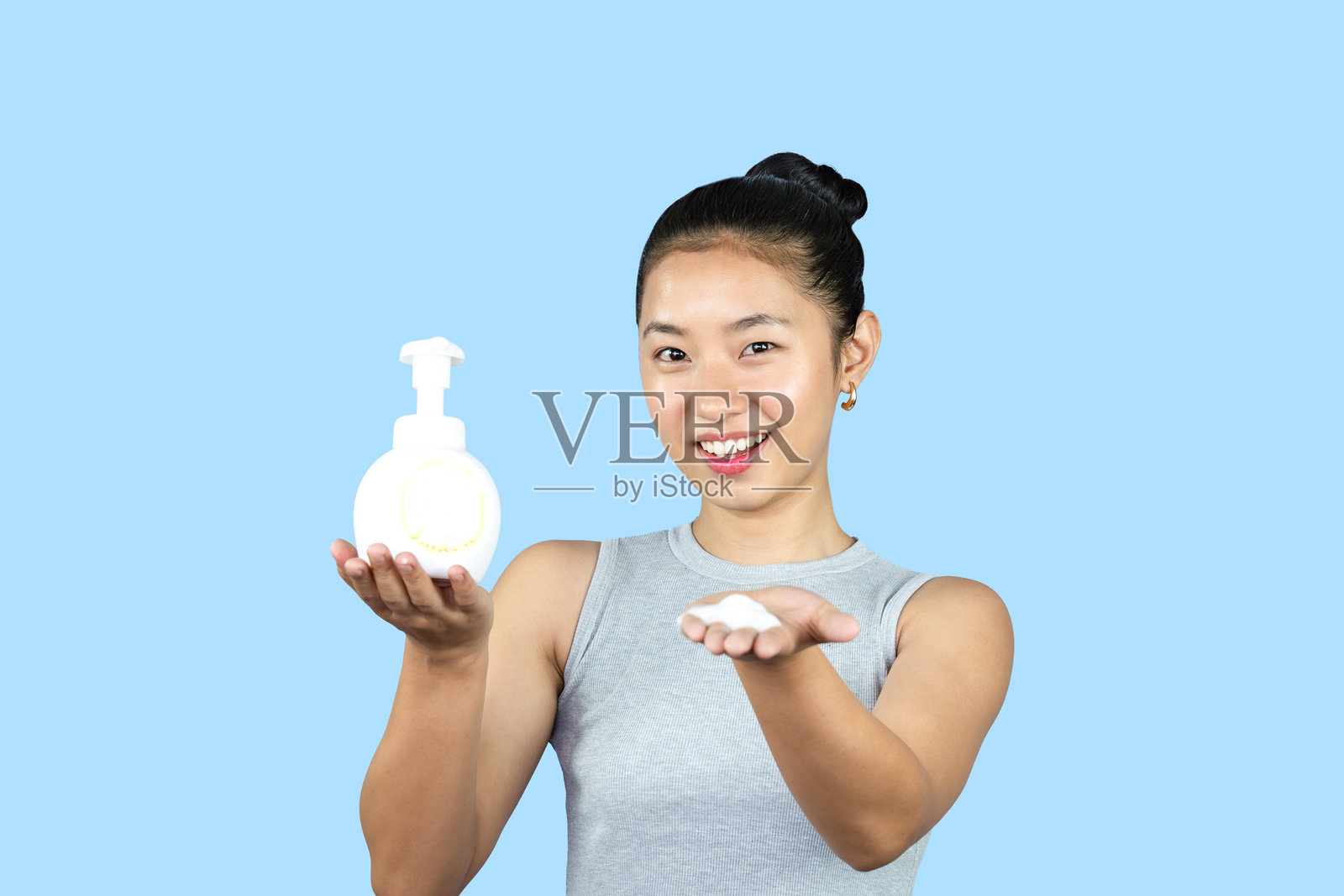 美容化妆的韩国女性模特，手持香皂和护肤乳霜，肌肤无痘，洁面产品照片摄影图片