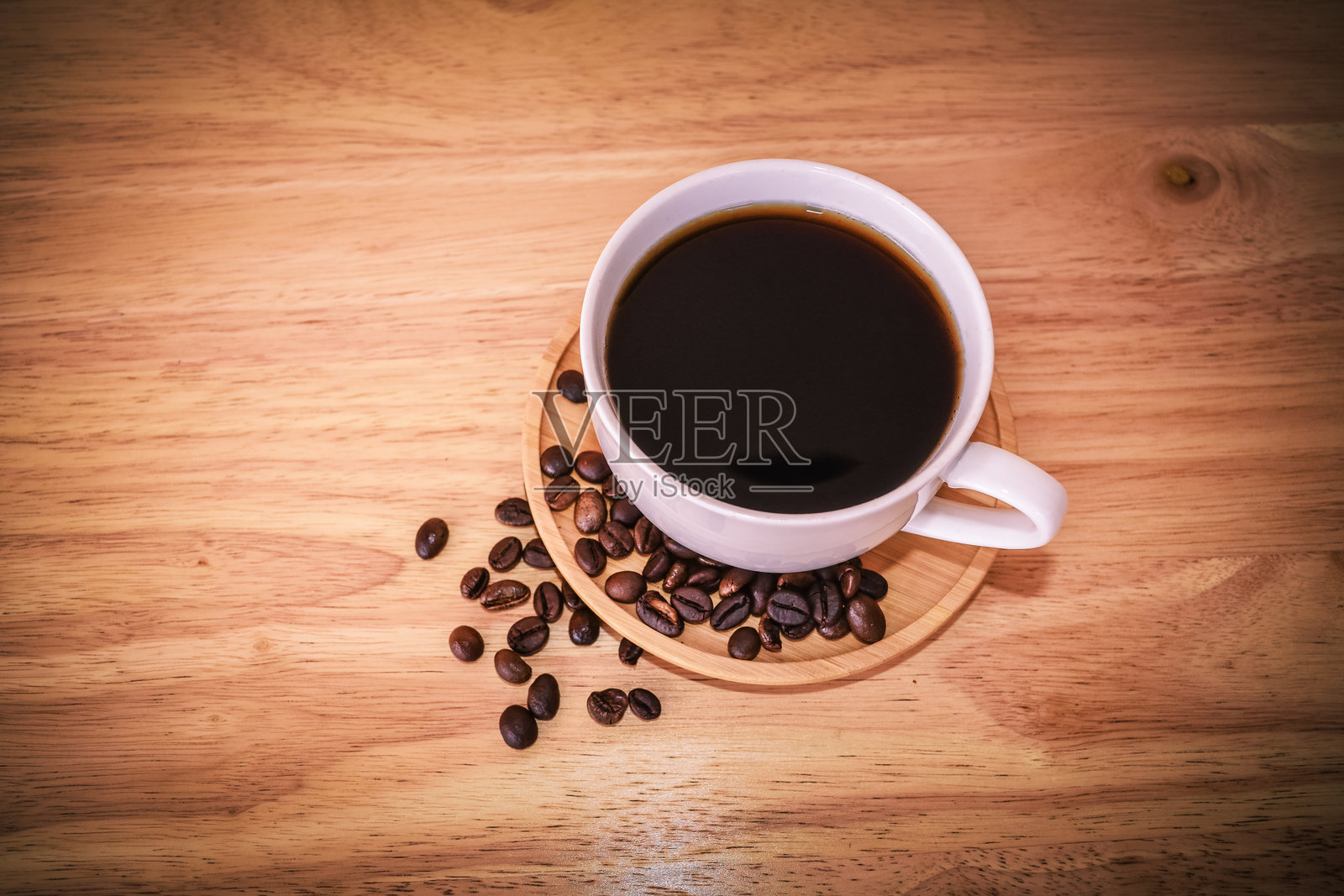 高角度视图的咖啡杯和桌上的咖啡豆照片摄影图片