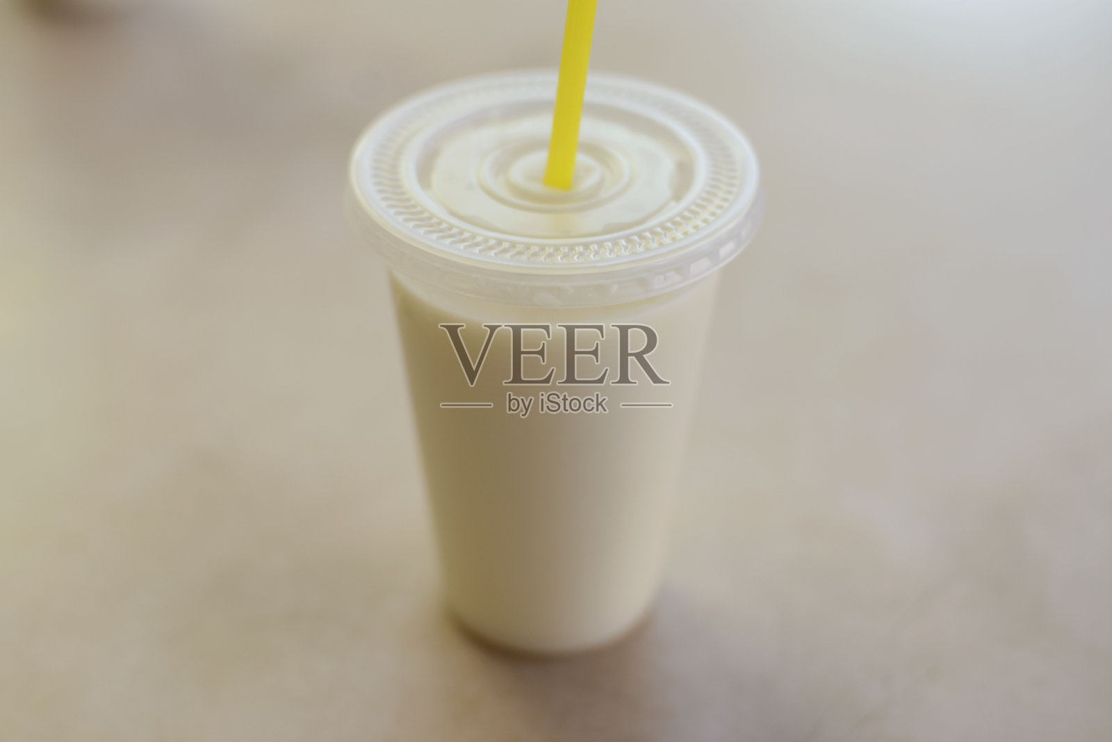 高角度视图的新鲜豆浆在桌子上的一次性杯子里照片摄影图片