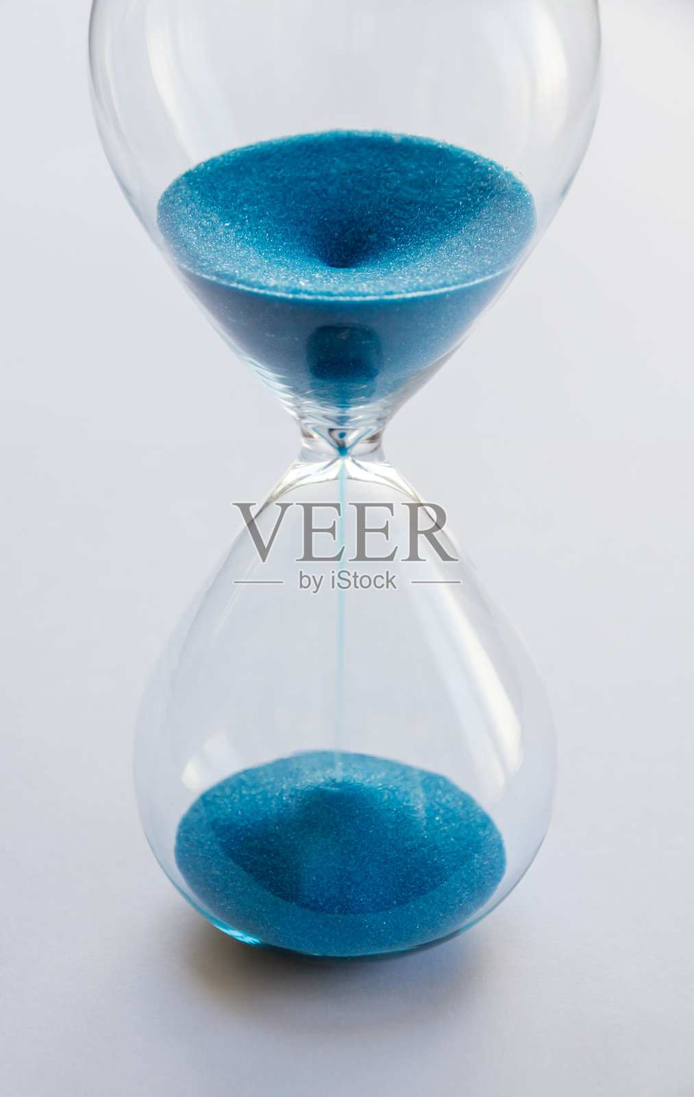 白色背景上孤立的蓝色沙子沙漏照片摄影图片