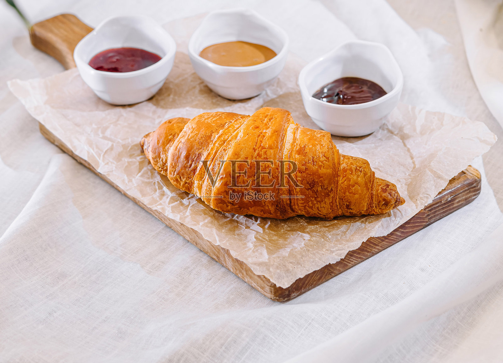新鲜出炉的可颂面包，搭配果酱和茶，作为早餐享用照片摄影图片