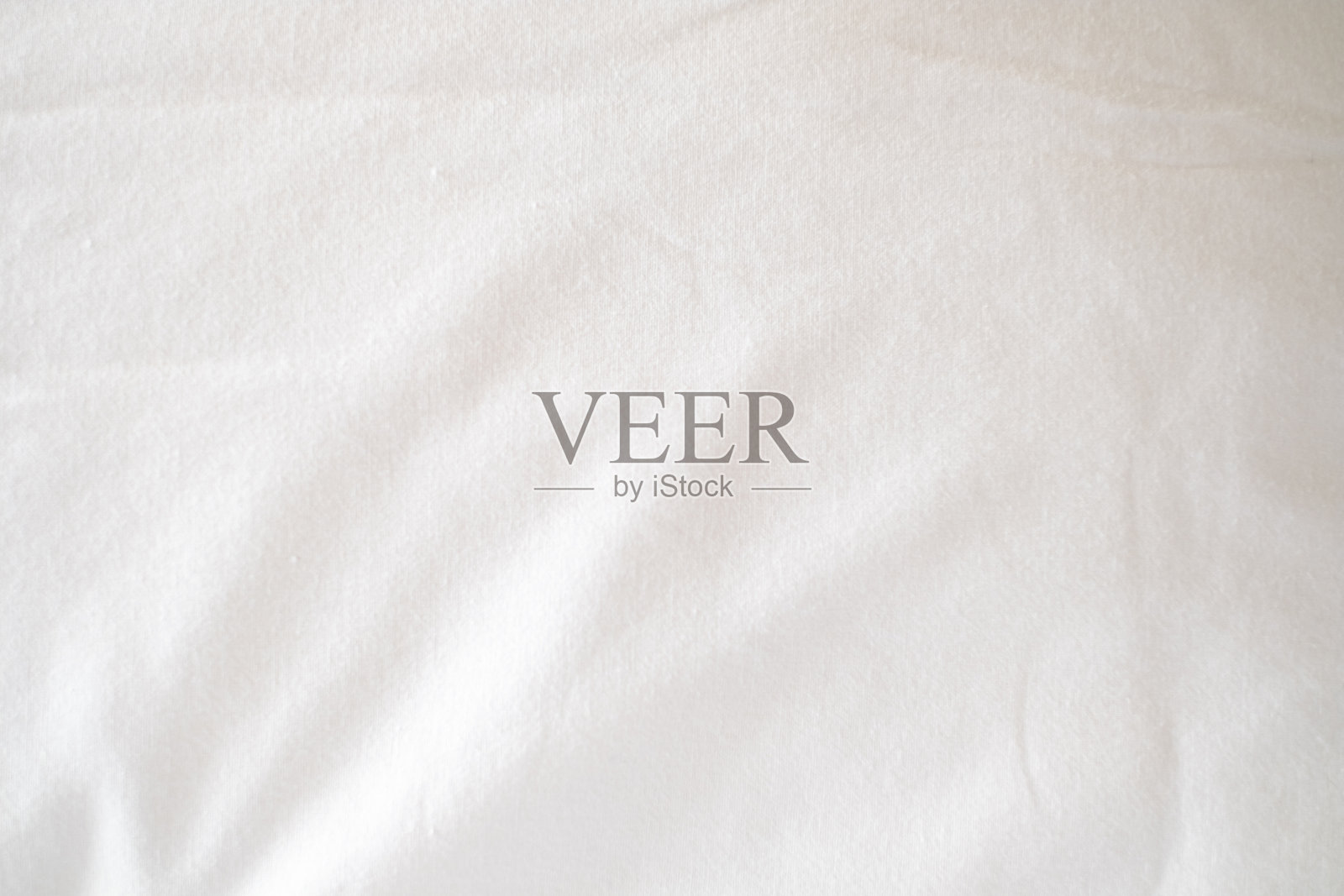 抽象的白色床单或白色皱纹织物背景纹理，带有留白：褶皱或皱纹的白色织物，柔和的焦点照片摄影图片