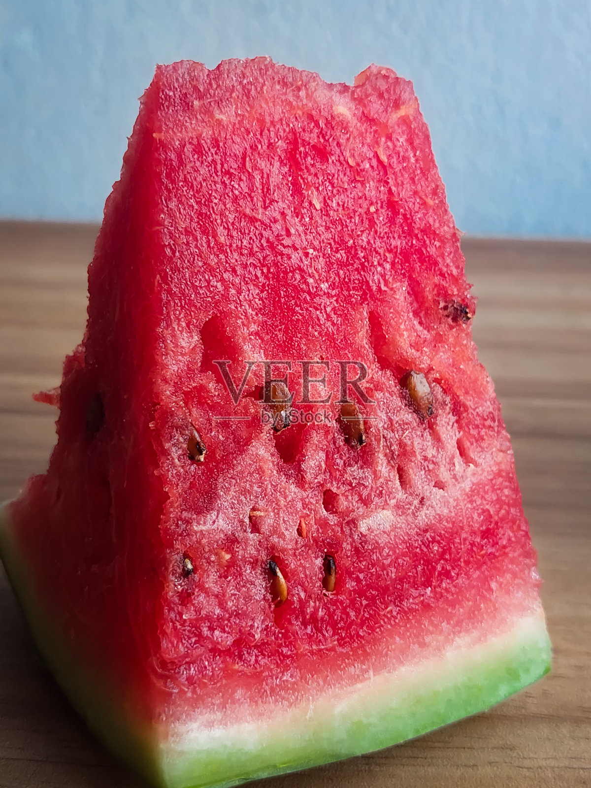 一片红色的西瓜，外面有绿色的皮。照片摄影图片