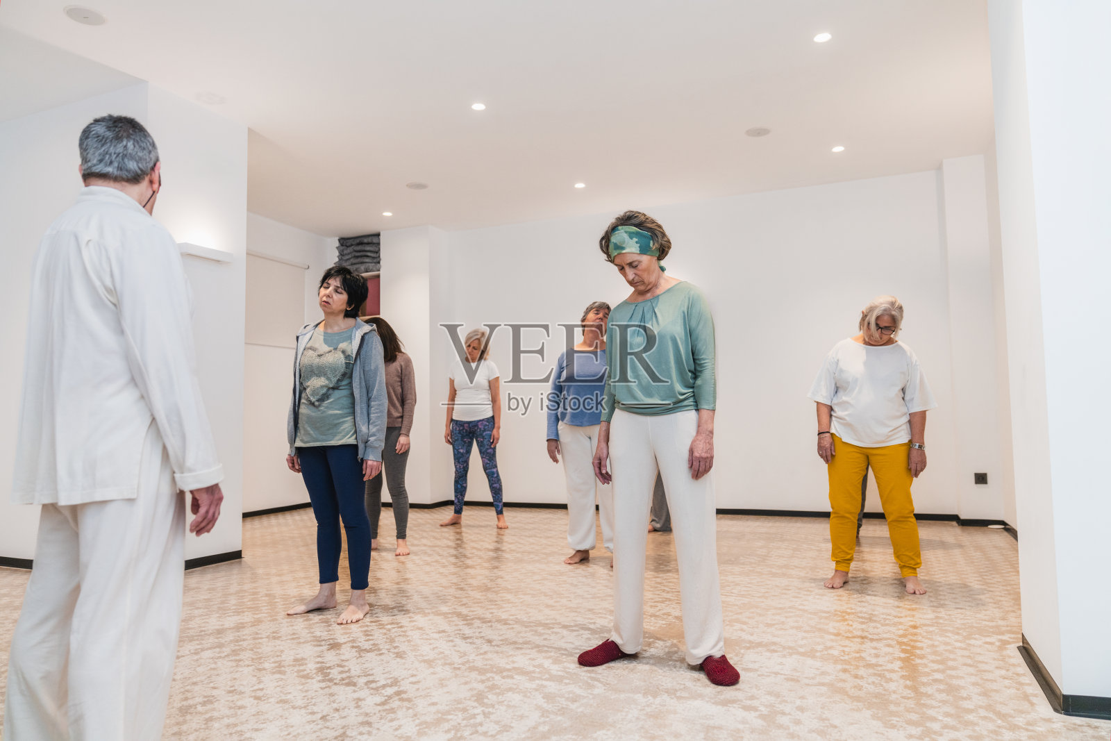 瑜伽课上的资深女性在教练的指导下进行放松练习照片摄影图片