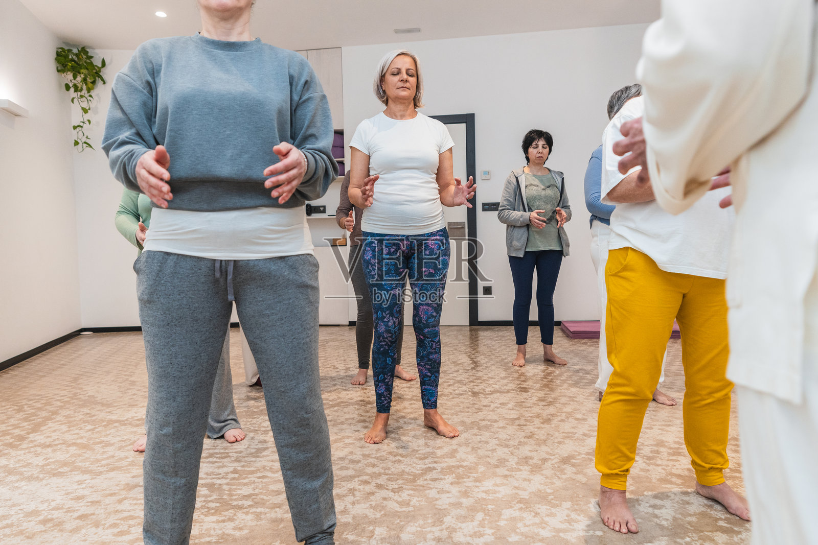 资深女性在瑜伽课上专注于正念和身体平衡照片摄影图片