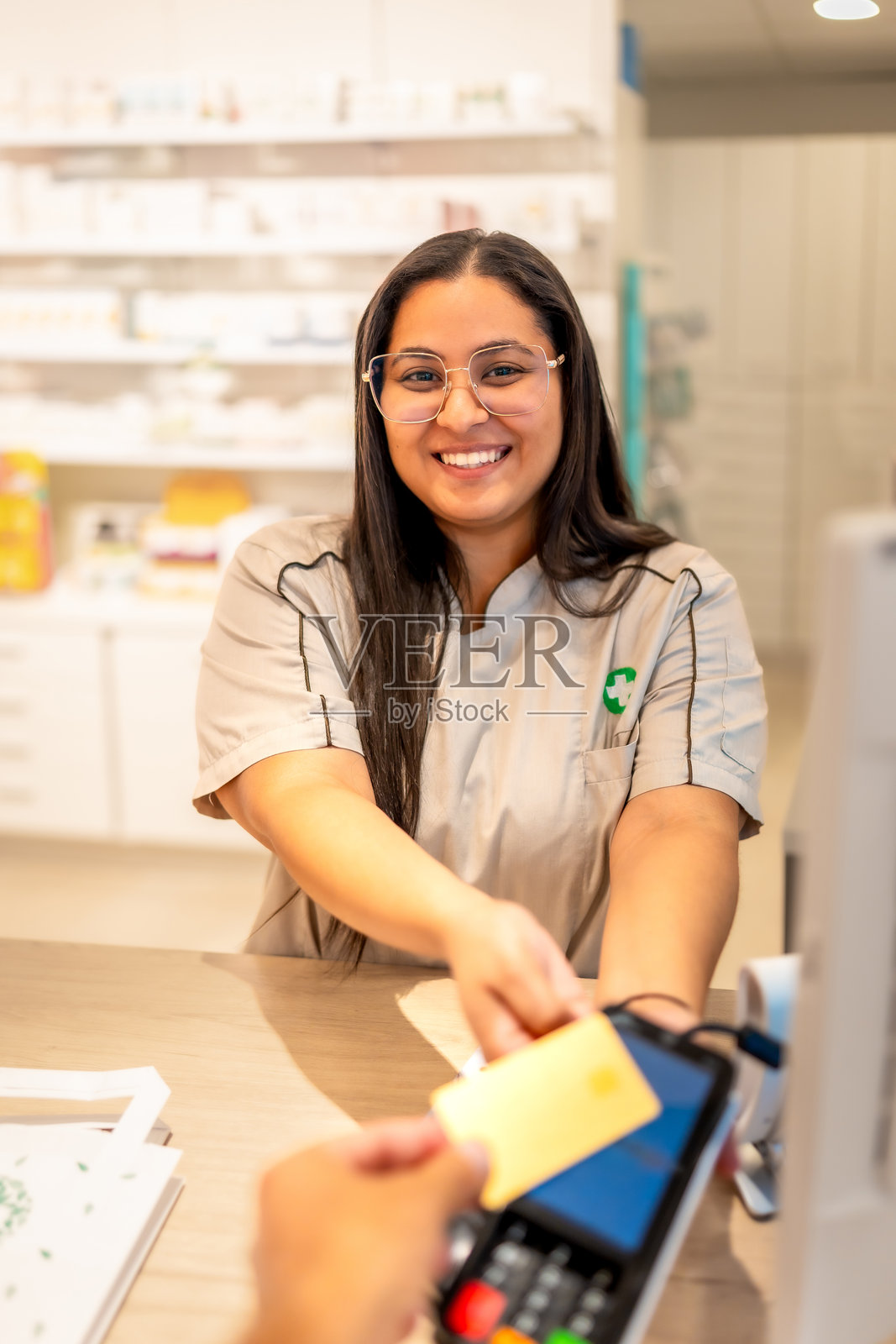 微笑的药剂师在为客户办理信用卡支付照片摄影图片