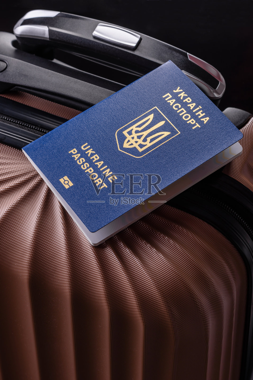 乌克兰公民的国际护照放在行李箱上照片摄影图片