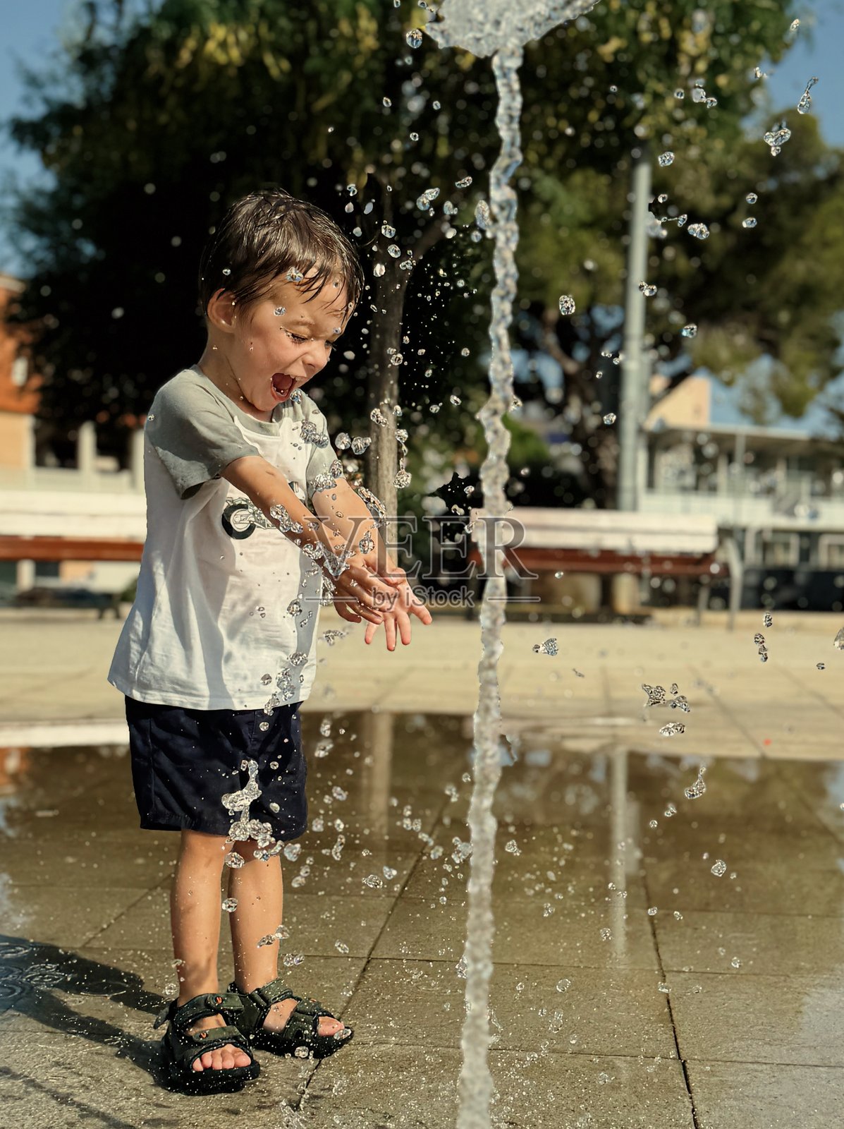 3岁男孩在城市公园玩水照片摄影图片