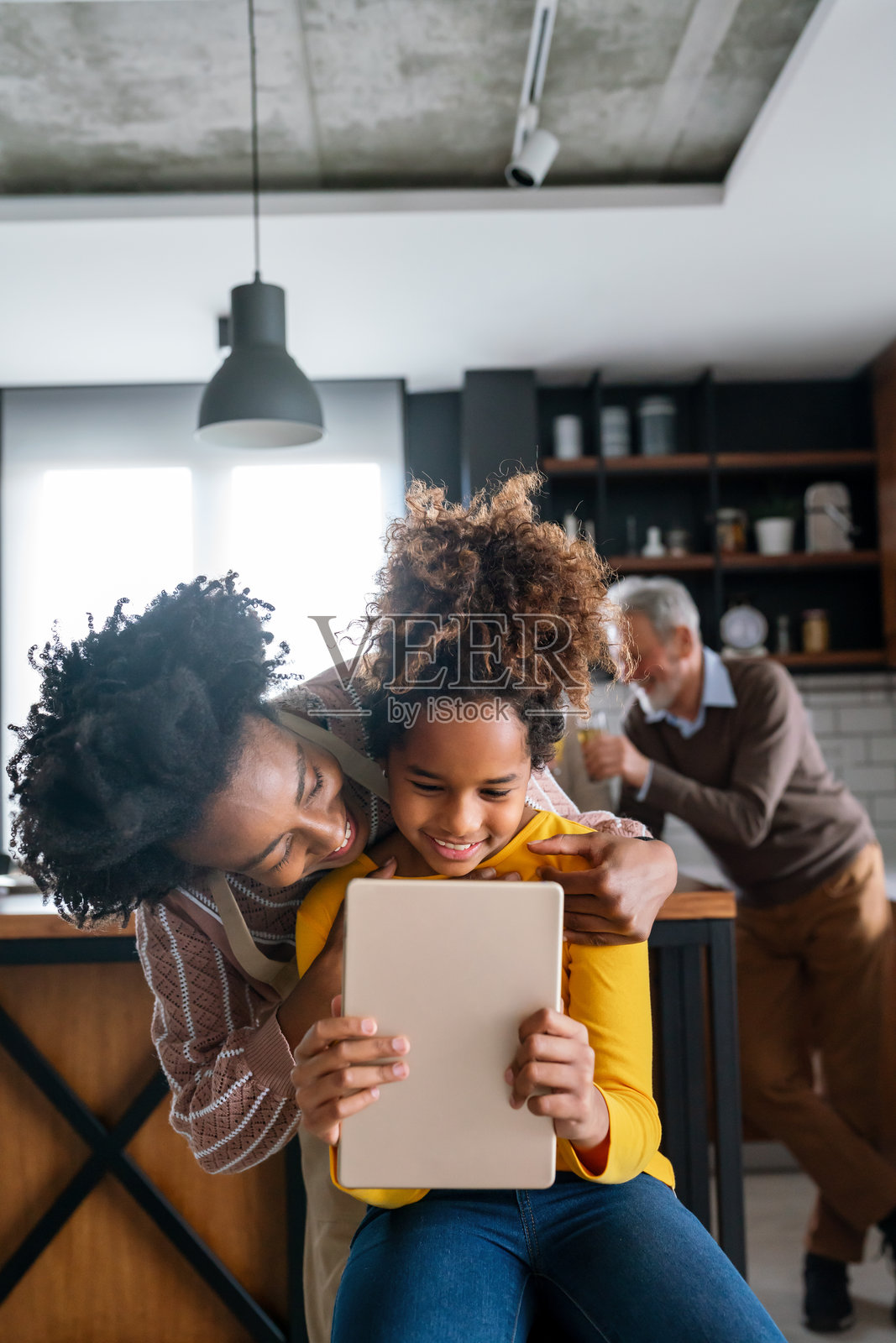 教育、家庭和学习的概念。母亲和女儿在家中使用平板电脑。照片摄影图片