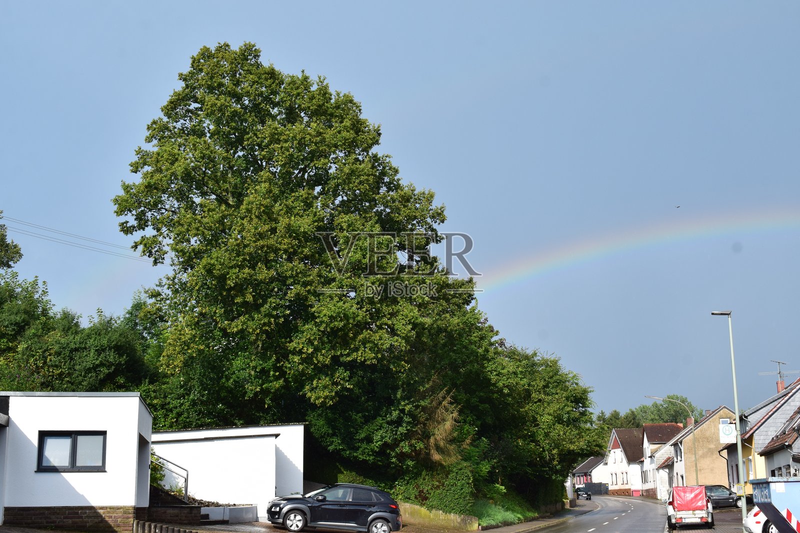 城镇上方的低弧彩虹照片摄影图片