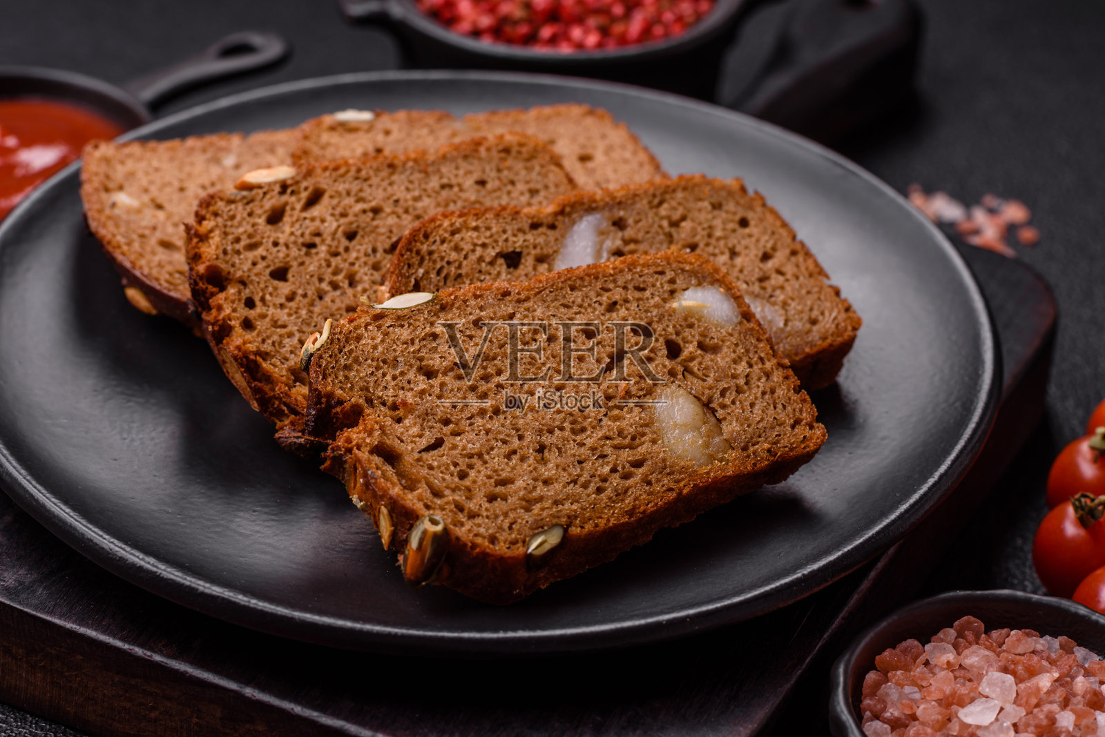 带有种子、谷物、盐和香料的棕色面包照片摄影图片