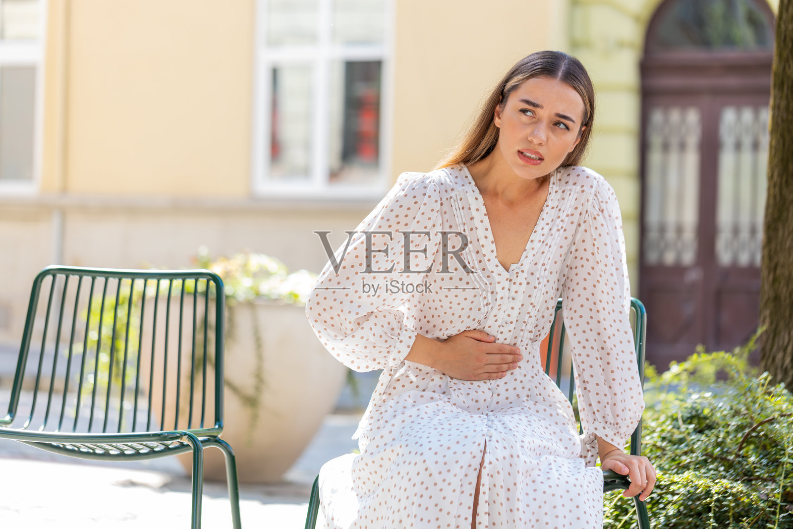 白人年轻女性旅行者感到突发强烈的腹部疼痛，胃炎问题照片摄影图片