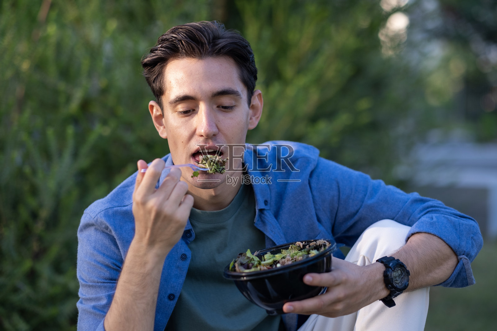 年轻男子在公园里享用健康食品，工作间隙放松。照片摄影图片