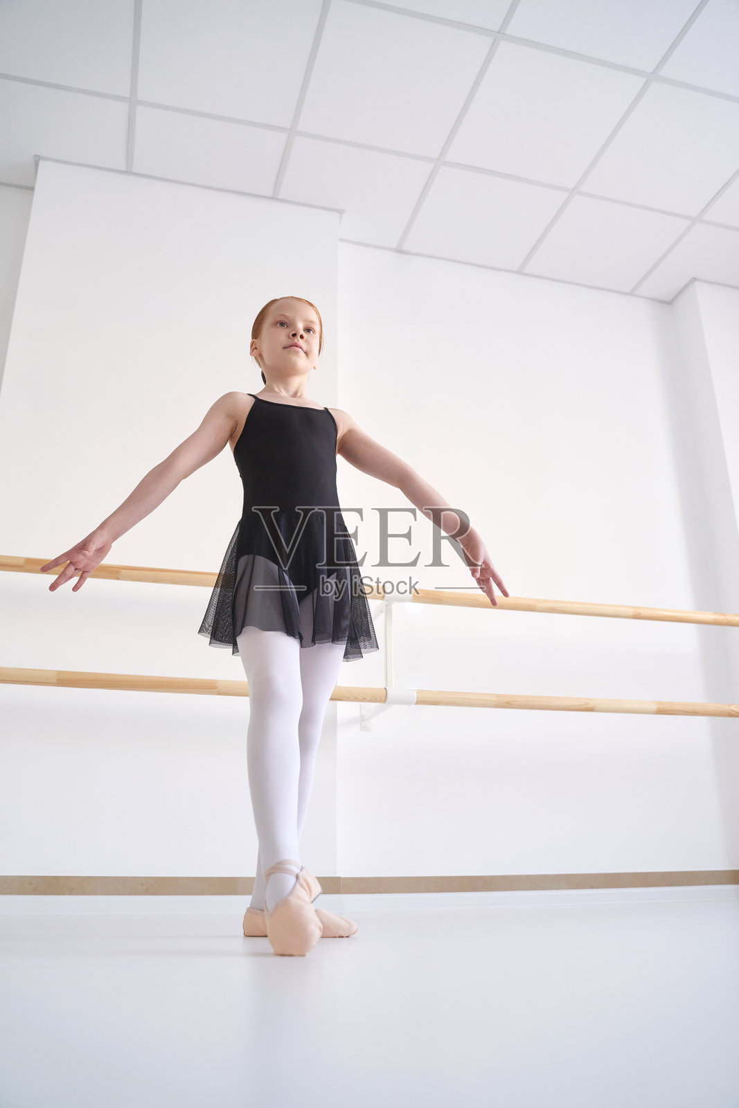 年轻的芭蕾女孩在舞蹈教室上课。训练表演。拉伸练习照片摄影图片