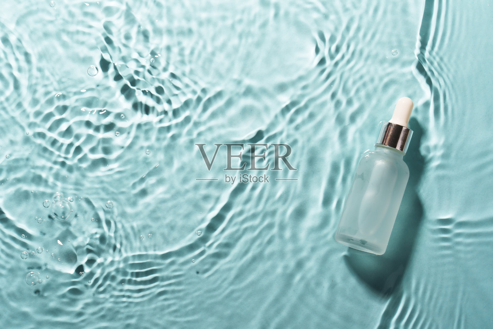 蓝色水中漂浮的药水瓶。照片摄影图片