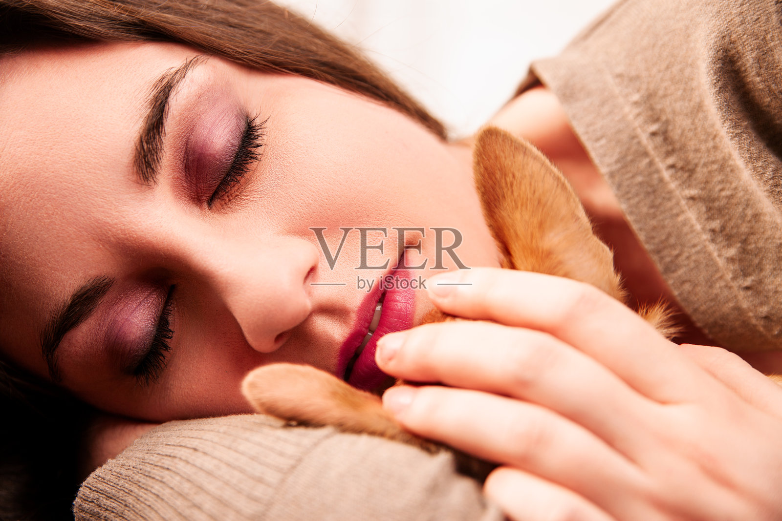 年轻女性在家中放松，抱着小狗。照片摄影图片