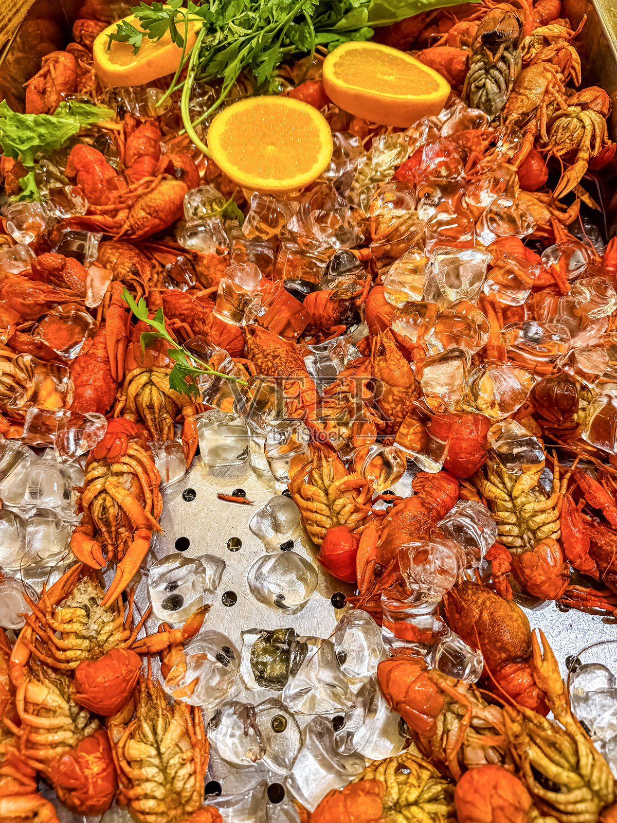 小龙虾。桌上放着红色煮熟的小龙虾，旁边有冰块，乡村风格，特写。照片摄影图片