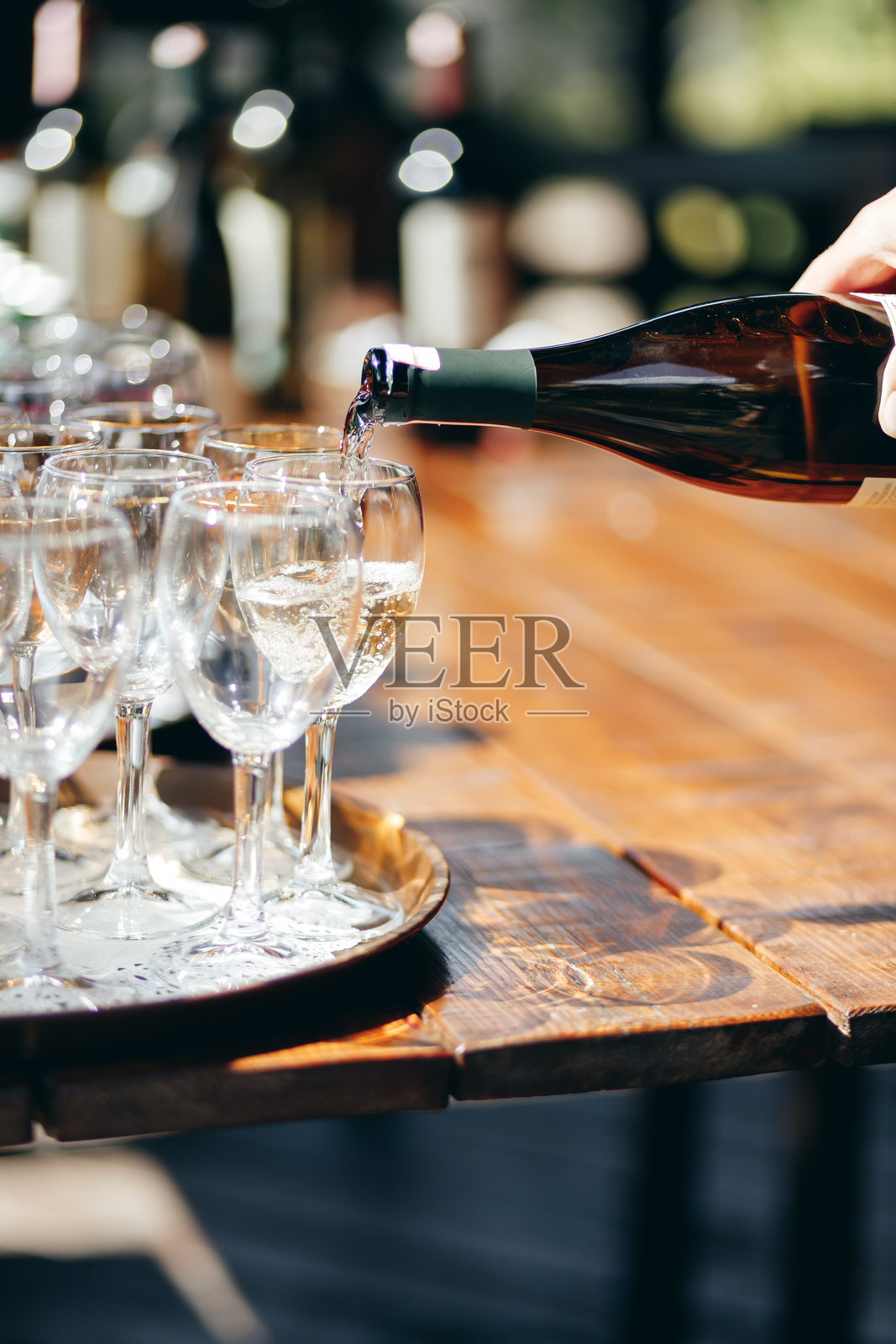 一名服务员在户外自助餐上为酒杯倒酒。照片摄影图片