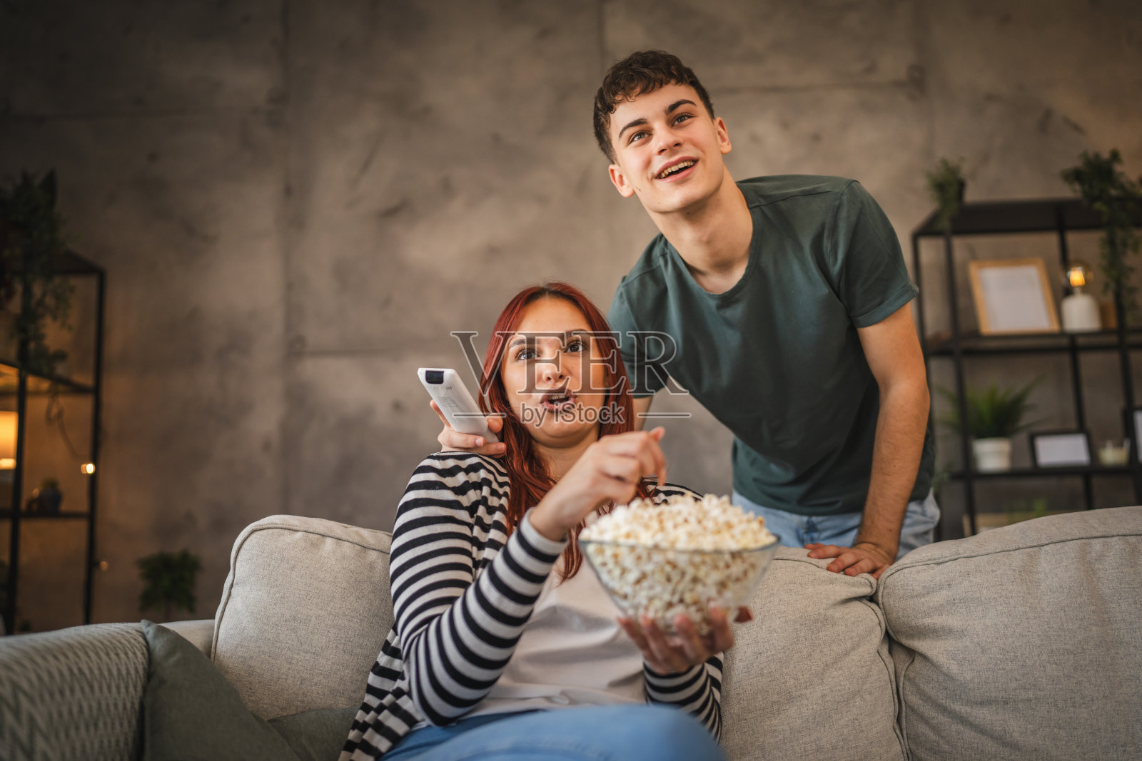 年轻情侣在家一起看电影吃爆米花照片摄影图片