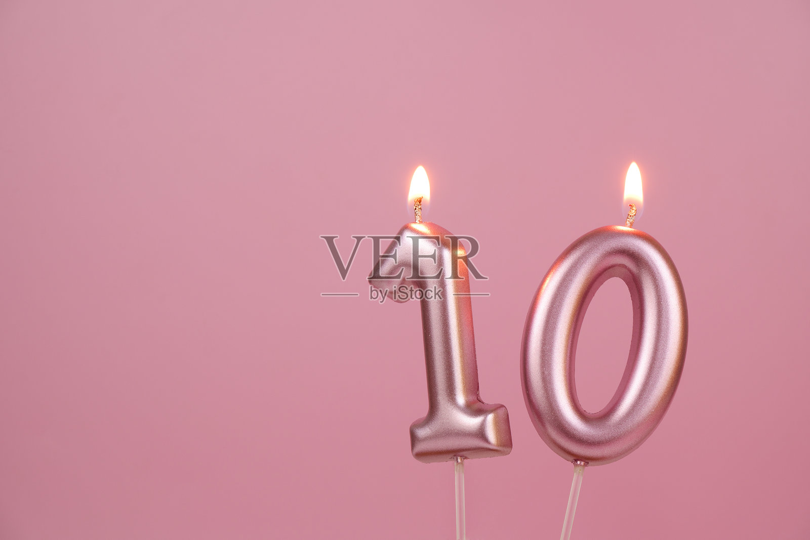 粉色背景上的粉色生日蜡烛，数字10照片摄影图片