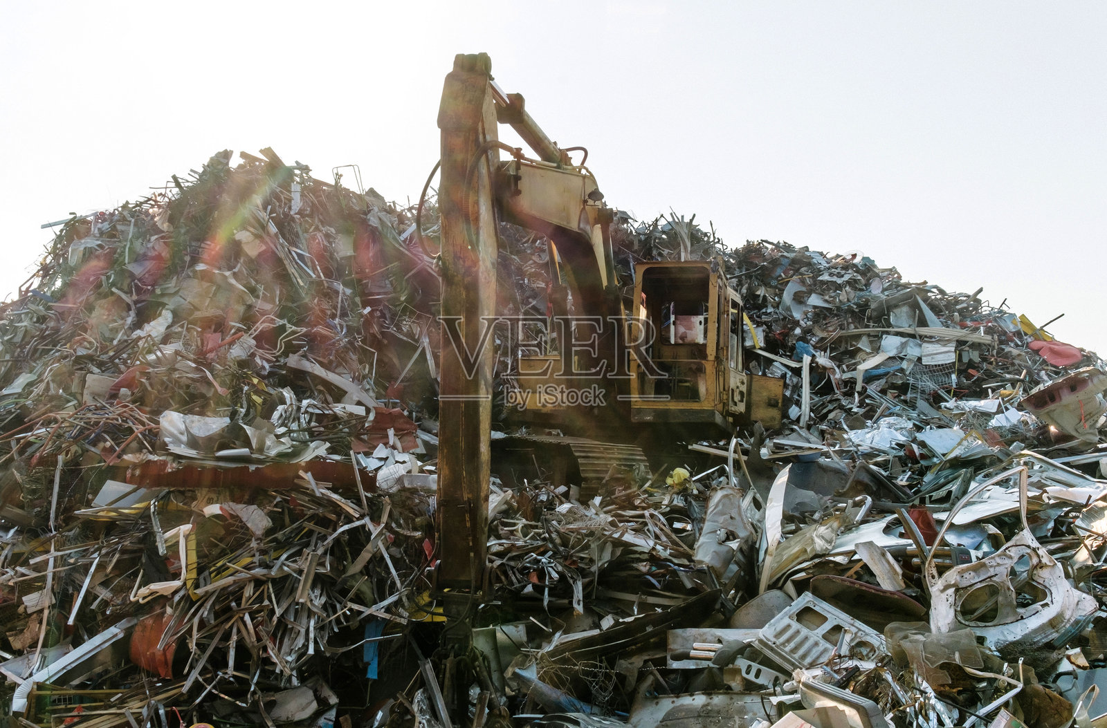 旧地球挖掘机在废品场的垃圾上照片摄影图片