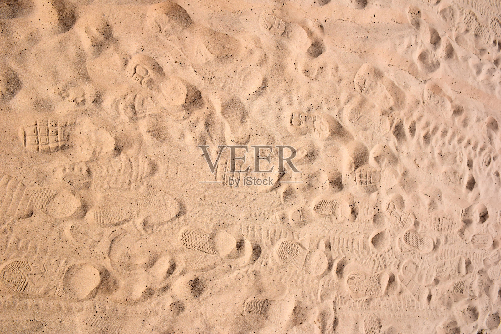 沙滩上有各种不同形状的鞋印。从上方俯视。照片摄影图片