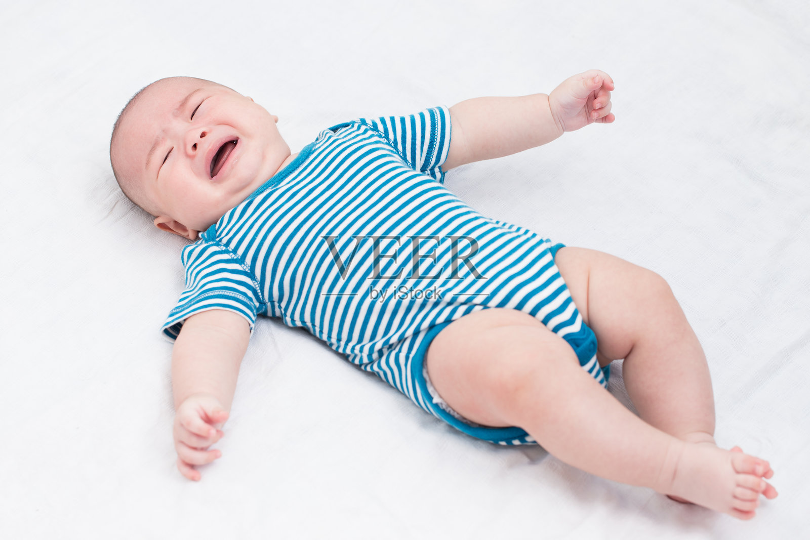 可爱的小男孩在家里的床上哭泣照片摄影图片