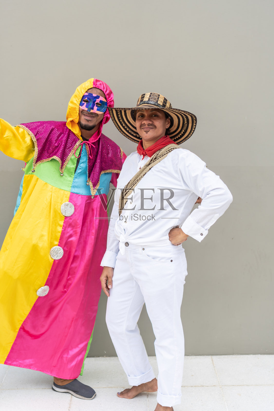 两个人穿着传统服装和小丑服装在狂欢节上摆姿势照片摄影图片