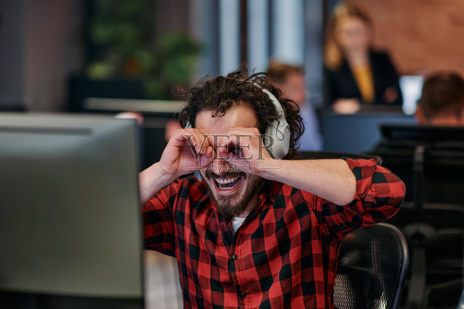 快乐的合作：一名男子在共享办公空间中以热情的手势拥抱远程工作。照片摄影图片