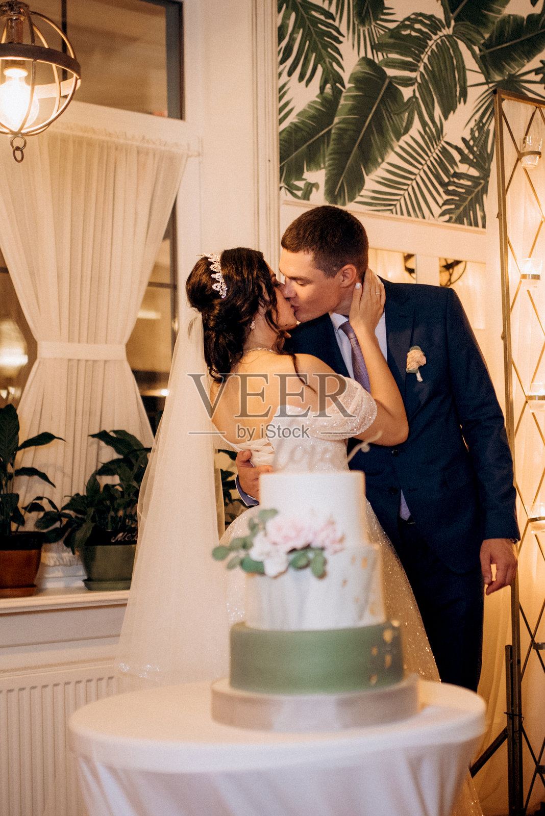 新婚夫妇快乐地切割并品尝婚礼蛋糕照片摄影图片