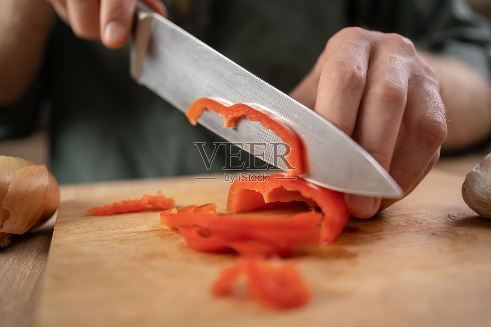 切菜。男性手在砧板上用刀切红椒，特写。厨房烹饪。照片摄影图片