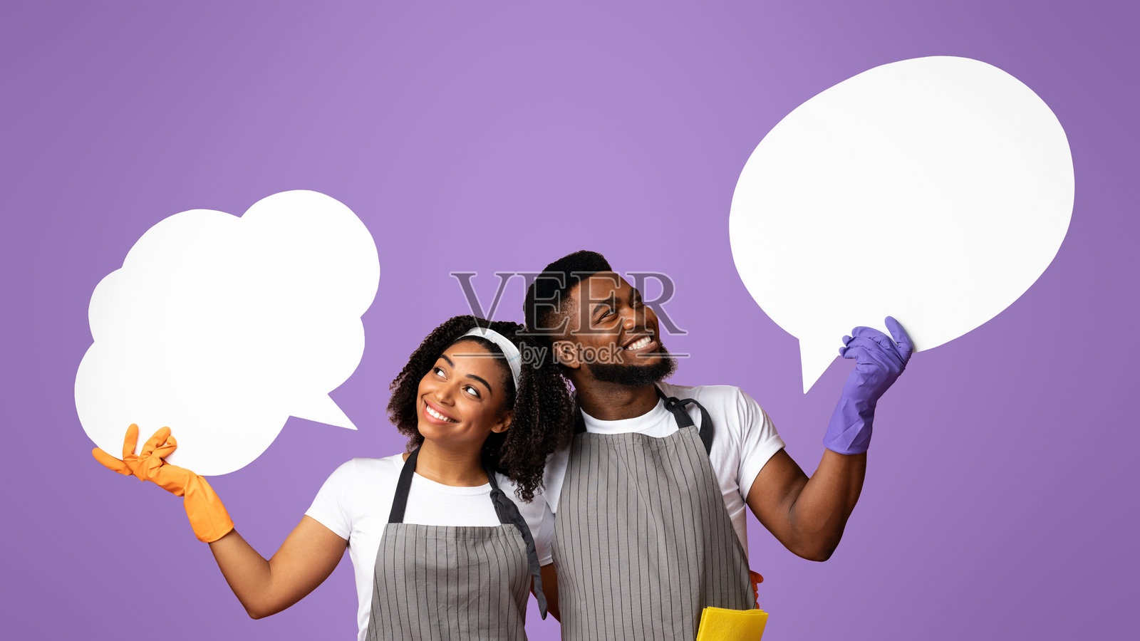 快乐的清洁工夫妇看着他们头顶上空的空白对话框照片摄影图片