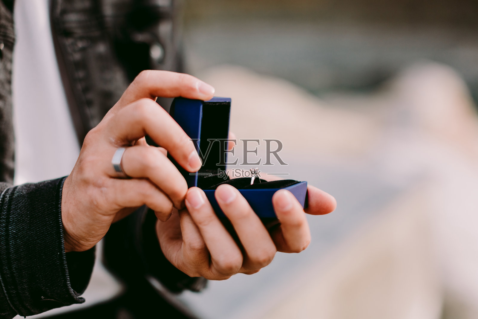 男子手持戒指盒的中部特写照片摄影图片