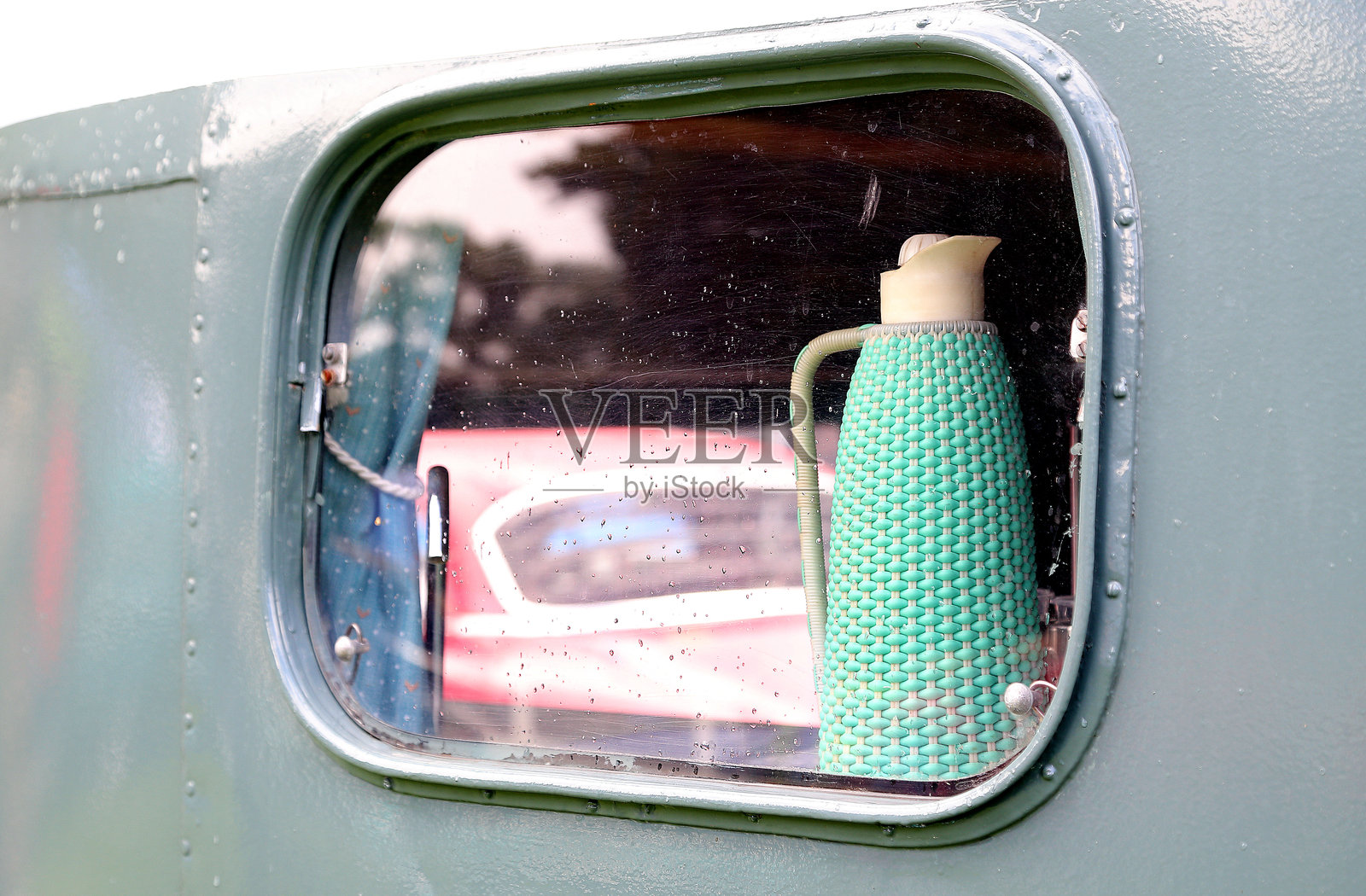 老式公交车窗中的保温饮料容器照片摄影图片