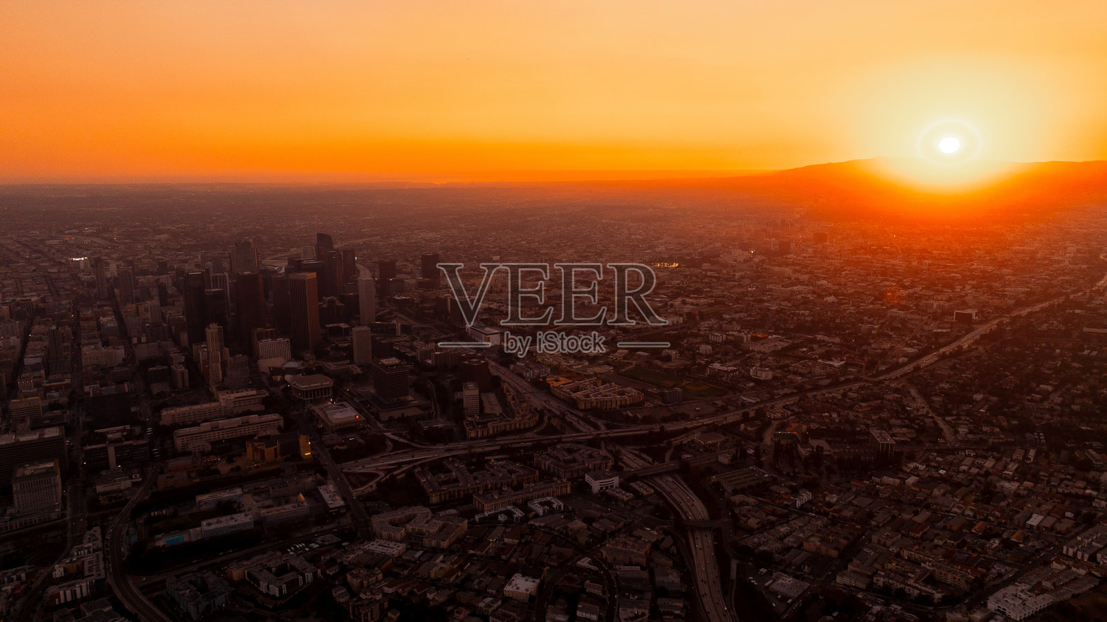 洛杉矶，加利福尼亚州，美国的全景，沐浴在橙色的日落光辉中。黄金时刻的城市中心鸟瞰图。照片摄影图片