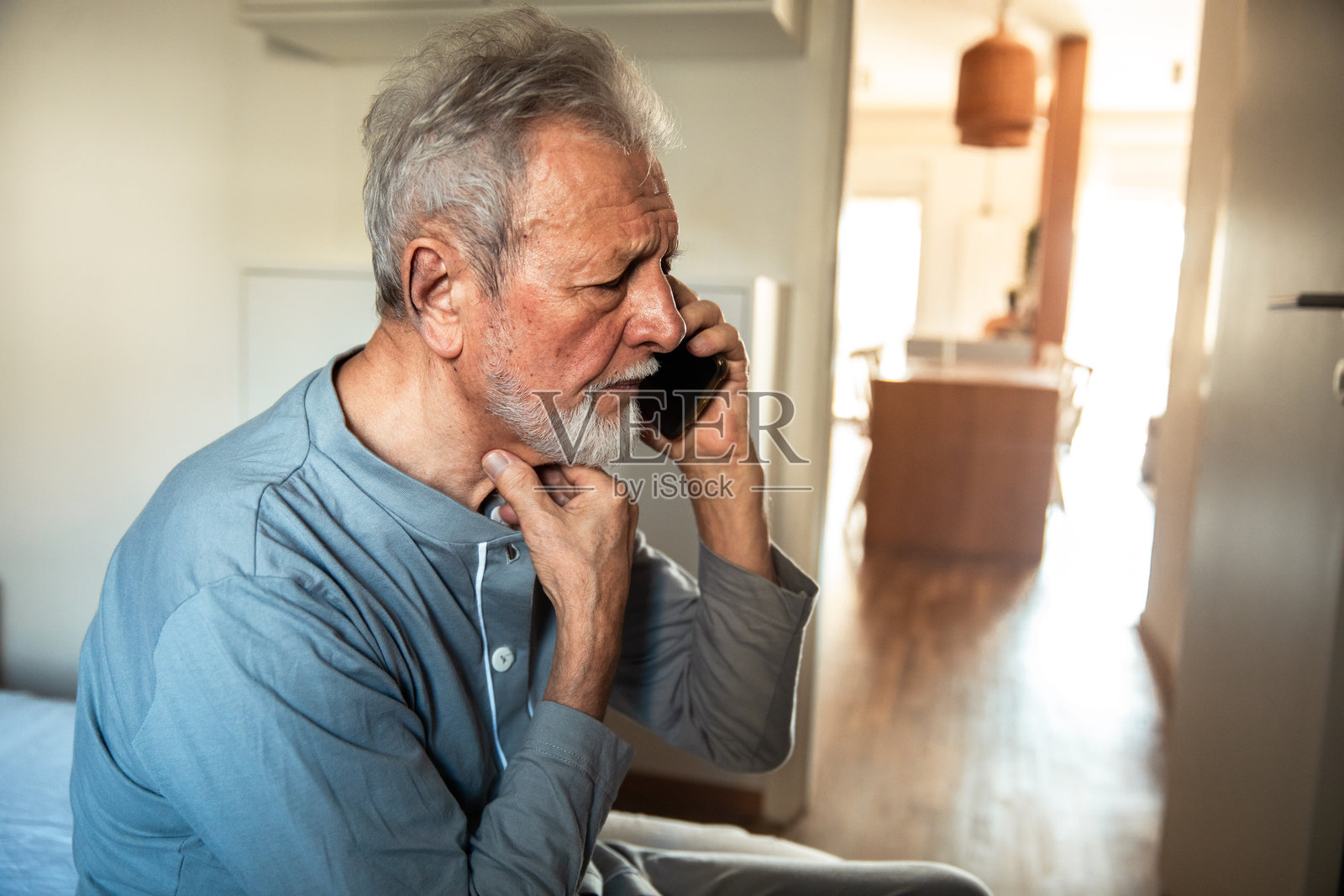 老年男子在卧室里早晨使用智能手机照片摄影图片
