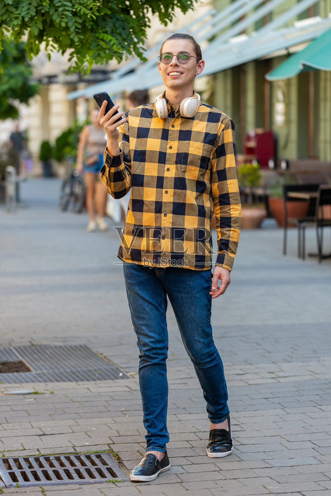 男子使用智能手机，正在输入社交媒体消息，寻找地图导航应用中的路线。照片摄影图片