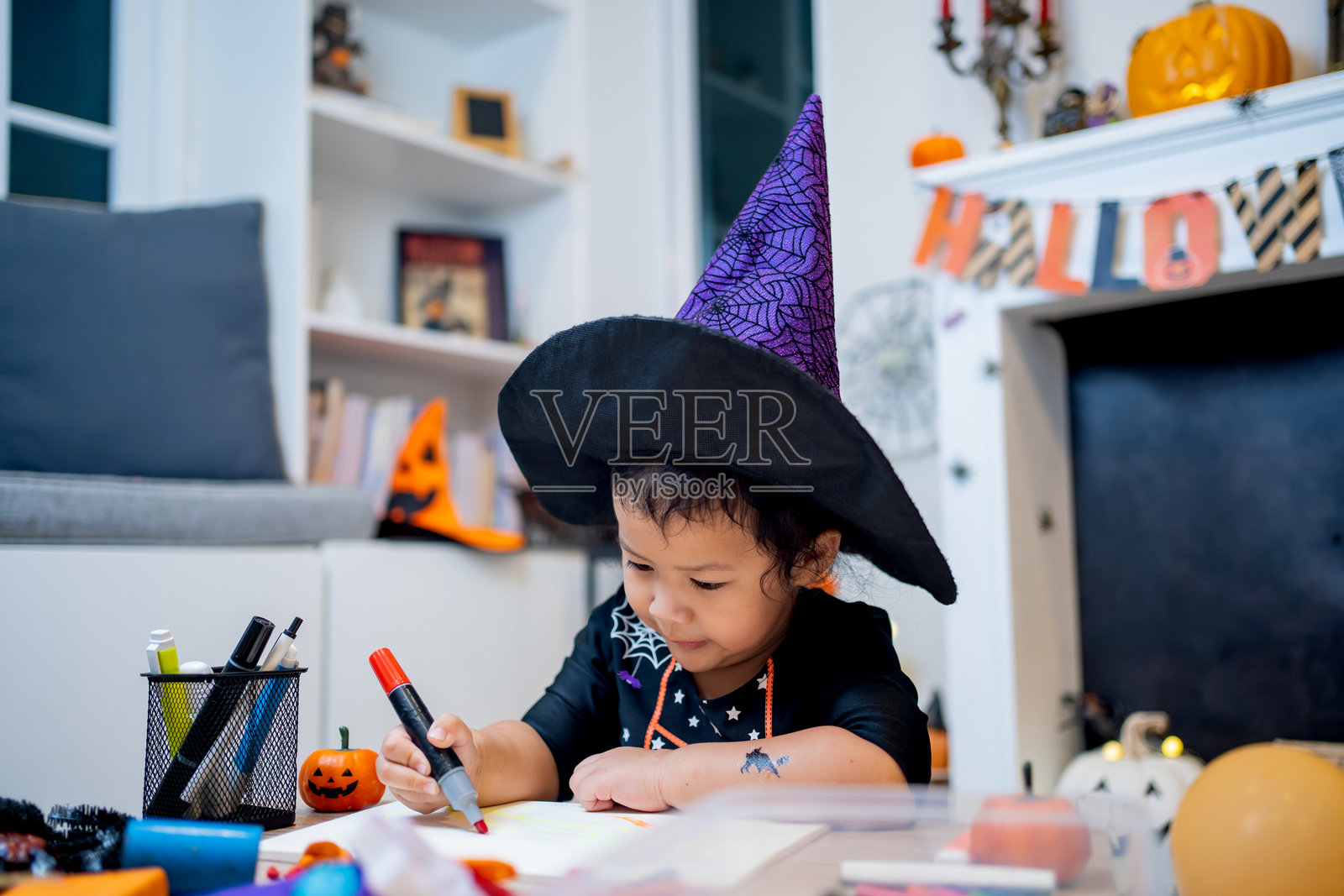 家庭庆祝活动中的万圣节儿童服装，秋季装饰的房间。照片摄影图片